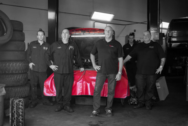 Reeves Team posing in front of vehicle in shop