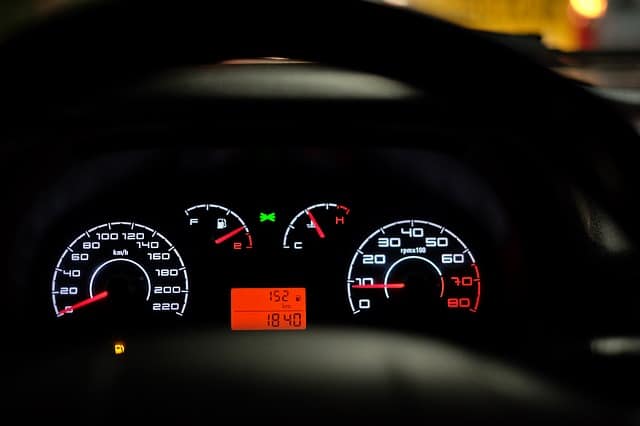 car dashboard with dashboard backlights on illuminating speedometer and other vehicle sensors
